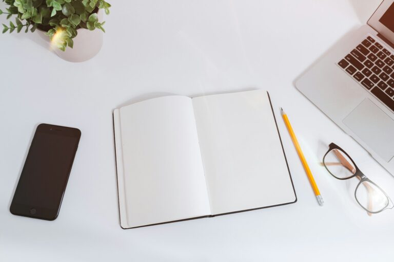 Mesa de trabalho com portátil e bloco de notas para planear um website.